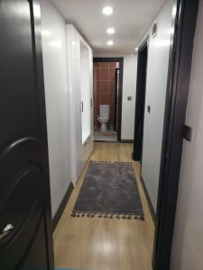 - un couloir avec une salle de bains pourvue de toilettes et d'un tapis dans l'établissement Han Apart, à Istanbul