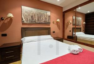 1 dormitorio con 1 cama blanca grande y espejo en El rincón del CAMPOAMOR - Piso céntrico en Oviedo., en Oviedo