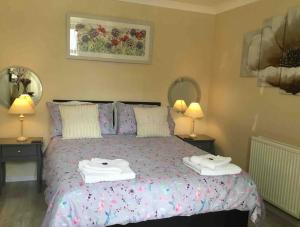 a bedroom with a bed with two towels on it at Plas Bach in Haverfordwest