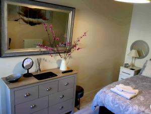 sypialnia z łóżkiem i komodą z lustrem w obiekcie Plas Bach w mieście Haverfordwest