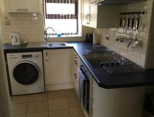 a kitchen with a sink and a washing machine at Plas Bach in Haverfordwest