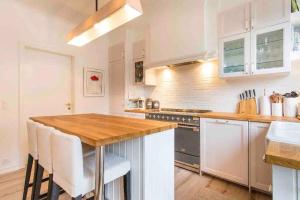 cocina con armarios blancos y encimera de madera en Stunning Villa overlooking lake, en Le Châtelard-Montreux