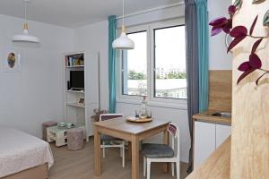 a small room with a table and a bedroom at Studio CAMINO with parking in Zadar