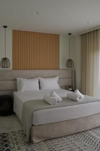 a bedroom with a large bed with two towels on it at URBAN SUITES ATHENS in Athens