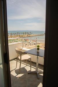 a balcony with a table and a view of the beach at Wave Beachfront Apartments in Durrës