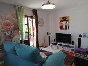 uma sala de estar com um sofá azul e uma televisão em Coquetty Housing In Santander Bay em El Astillero