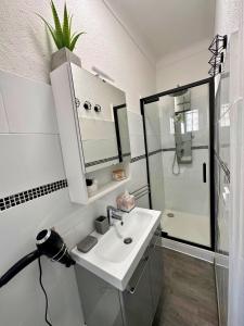 a white bathroom with a sink and a shower at Paradis - Hyper Centre, a deux pas de la Mer ! in Canet-en-Roussillon