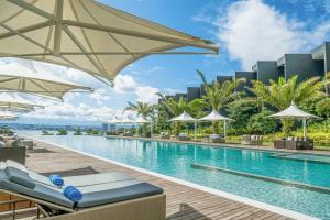 a pool at a resort with chairs and umbrellas at Discovery Samal in Samal