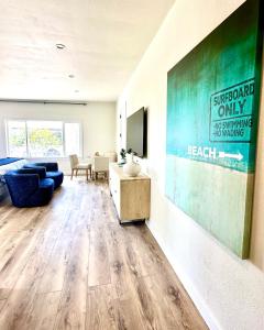 a living room with a couch and a television on a wall at AZUL on Avenida Del Mar (1/2 Mile to the PIER!) in San Clemente