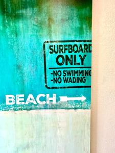 a sign on a wall that reads surfboard only no swimming no walking at AZUL on Avenida Del Mar (1/2 Mile to the PIER!) in San Clemente