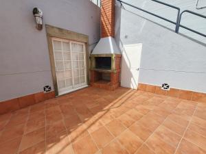 een lege patio met een buitenhaard in een huis bij Apartamento playa Sanxenxo in Sanxenxo