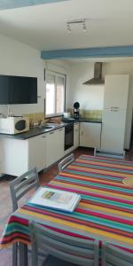 una cocina con una mesa con una alfombra colorida en Domaine Vents Du Sud, en Vingrau