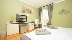 1 dormitorio con 1 cama y escritorio con TV en F-1010 Strandhaus Mönchgut Bed&Breakfast DZ 37 strandnah, inkl Frühstück en Lobbe
