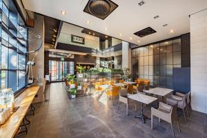 a restaurant with tables and chairs in a building at The Hong C Hotel in Gangneung