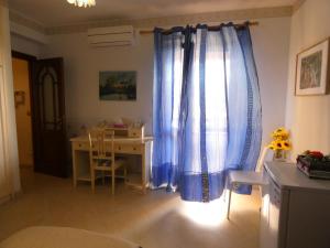 a room with a desk and a blue curtain at Villa Magnolia B&B in Taormina