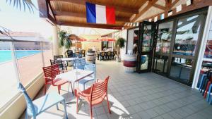 a restaurant with a table and chairs on a patio at Le Costa Gloria - Sud Nantes Camping de la Prairie in Saint-Hilaire-de-Riez