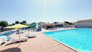 a large swimming pool with chairs and umbrellas at Le Costa Gloria - Camping de la Prairie in Saint-Hilaire-de-Riez
