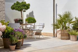 une terrasse avec des plantes en pot, une table et des chaises dans l'établissement ABC Hotel, à Blankenberge