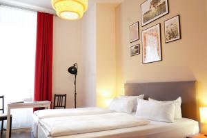 a bedroom with two beds and a red curtain at Aparthotel Mitte in Dresden