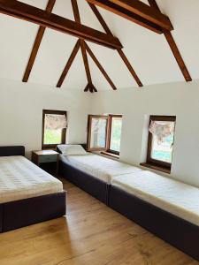 two beds in a room with wooden floors at Inas & Lemia Forrest Homes with Outdoor Swimming Pool in Bihać