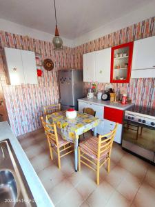 a kitchen with a table and chairs and a kitchen with a sink at Room in Guest room - La Palma Royal Room Summer in Cagliari