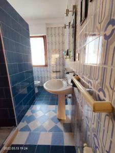 a bathroom with a sink and a blue tiled wall at Room in Guest room - La Palma Royal Room Summer in Cagliari