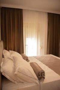 a large white bed in a bedroom with a window at Wave Beachfront Apartments in Durrës