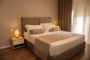 a bed with two pillows on it in a bedroom at Wave Beachfront Apartments in Durrës