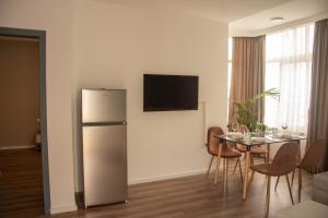 a kitchen and dining room with a refrigerator and a table at Wave Beachfront Apartments in Durrës