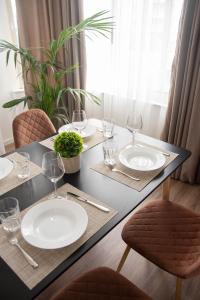 a dining table with two white plates and wine glasses at Wave Beachfront Apartments in Durrës