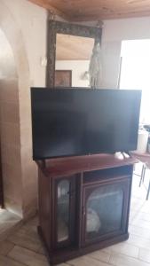 einen TV auf einem Holztisch in der Unterkunft Tulip House in Yerakárion