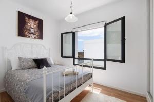 sypialnia z białym łóżkiem i oknem w obiekcie Casa Gardenia w Costa Teguise