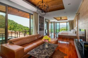 a living room with a brown leather couch and a bed at President R1-3 The Height Khaoyai 3BR byน้องมังคุด in Ban Huai Sok Noi