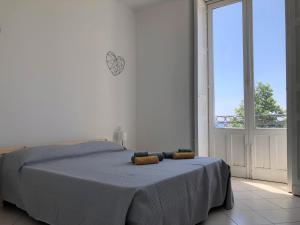 ein Schlafzimmer mit einem Bett und einem großen Fenster in der Unterkunft Elephant Sea View in Catania
