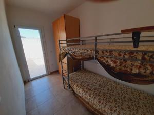 1 dormitorio con 2 literas y puerta en Appartamento MaRi con piscina, en Torre Lapillo