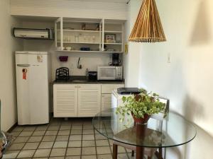 uma cozinha com uma mesa de vidro e um frigorífico em Studio encantador com vista mar em Salvador