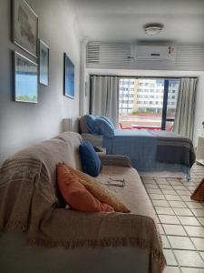 ein Schlafzimmer mit einem Bett und einem großen Fenster in der Unterkunft Studio encantador com vista mar in Salvador