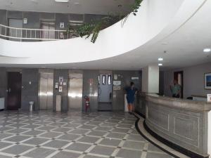 a woman standing in the lobby of a building at Studio encantador com vista mar in Salvador
