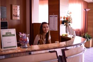 una mujer sentada en un bar en un restaurante en Hotel Gabry, en Cervia