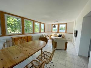 sala de estar con mesa de madera y sillas en Hostel DünenMeer en Kühlungsborn