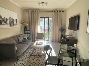 a living room with a couch and a table at Executive Modern Apartment in Fourways
