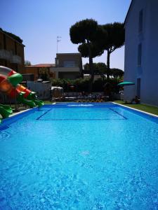 una grande piscina blu con scivolo d'acqua di Suite Apartments a Cervia