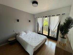 1 dormitorio con cama y ventana grande en Le sciezois, en Sciez