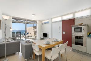 een keuken en eetkamer met een tafel en een bank bij Casa Médano 19 By Médano Rentals in El Médano +19 foto's