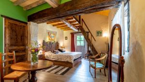 a bedroom with a bed and a table in a room at La Maison de Yûka in Plieux +37 photos