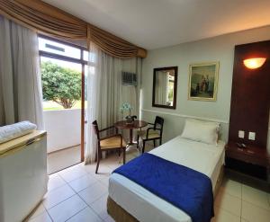 a hotel room with a bed and a table at Hotel Alvorada Taguatinga - Antigo Hotel Atlantico in Taguatinga