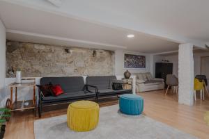 un soggiorno con divano e 2 letti singoli di Ndussole Guest House a Porto