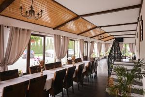 a row of tables and chairs in a room with windows at Casa Isabela in Putna