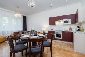 a kitchen and living room with a table and chairs at Luxurious & Unique Apartment Mickiewicza Cracow by Renters Prestige in Kraków