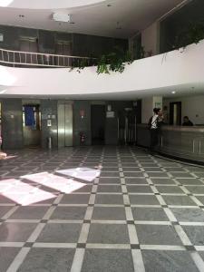 un homme prenant une photo d'un couloir dans un bâtiment dans l'établissement Flat encantador no Atlantic Towers, à Salvador